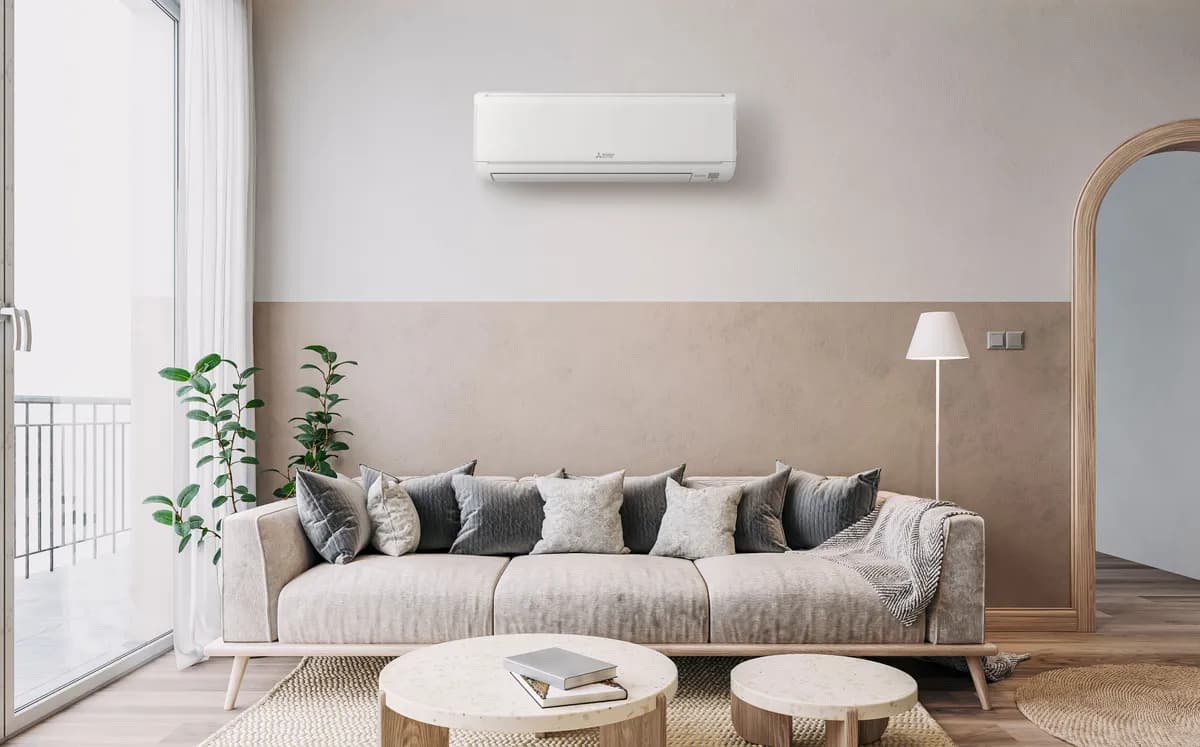 Mitsubishi Electric wall-mounted mini split indoor unit above a living room sofa